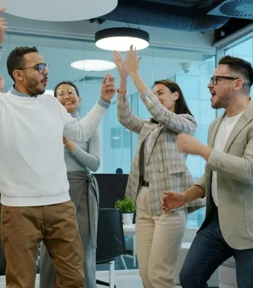 Diverse group of colleagues celebrating a project success in the office