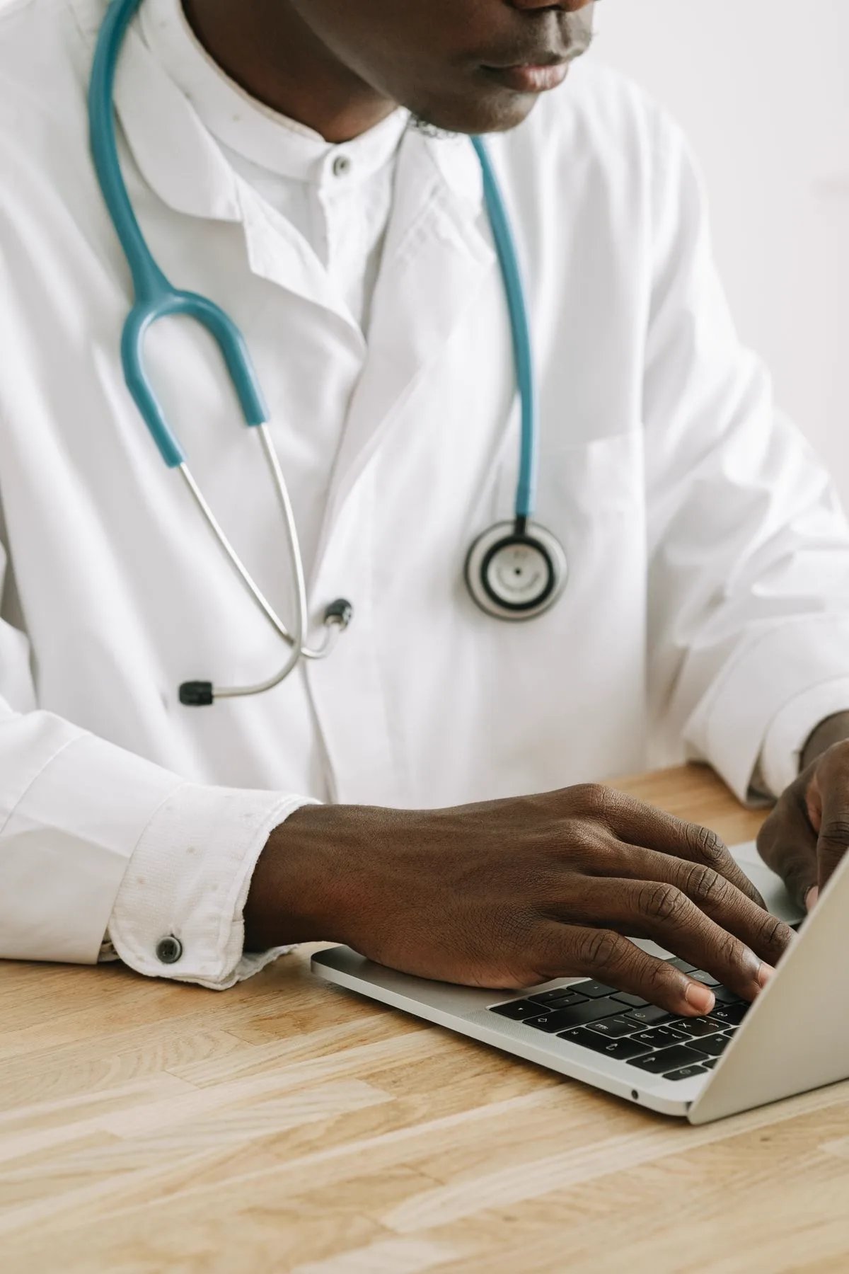 Doctor with a stethoscope working on a laptop