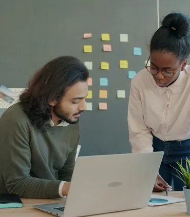 Two colleagues discussing a project at a desk