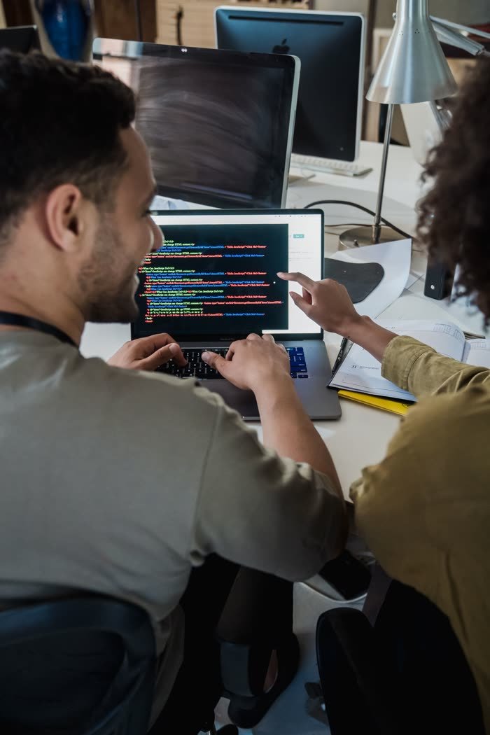 Designers reviewing an interface build together on a laptop