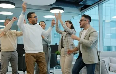 Diverse group of colleagues celebrating a project success in the office